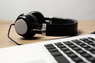 Photo of Stylish headphones and laptop on table. Modern technology