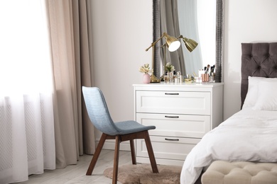 Photo of Interior of bedroom with dressing table near wall