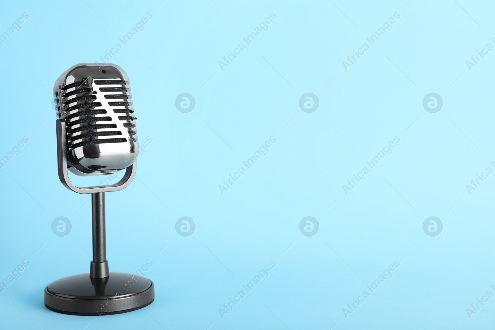 Photo of Retro microphone on color background, space for text