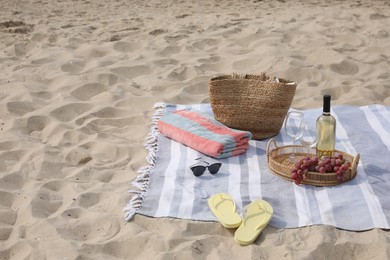Bag, blanket, wine and other stuff for beach picnic on sand