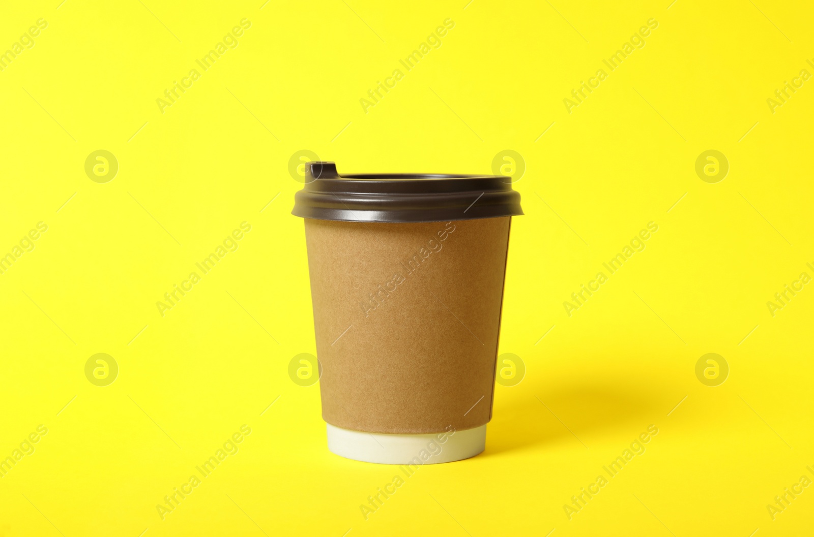 Photo of Takeaway paper coffee cup on yellow background