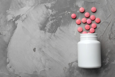 Photo of Bottle with pills on table, flat lay. Space for text