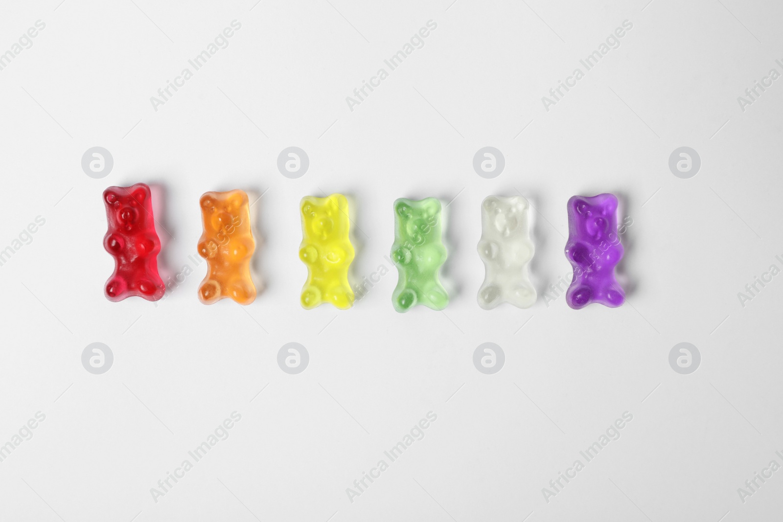 Photo of Delicious color jelly bears on white background, top view