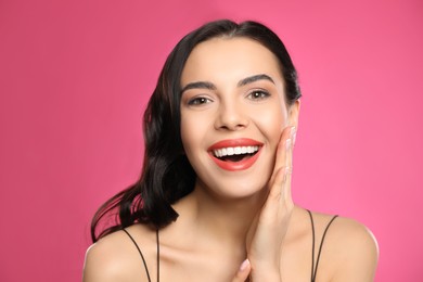 Photo of Portrait of surprised woman on pink background