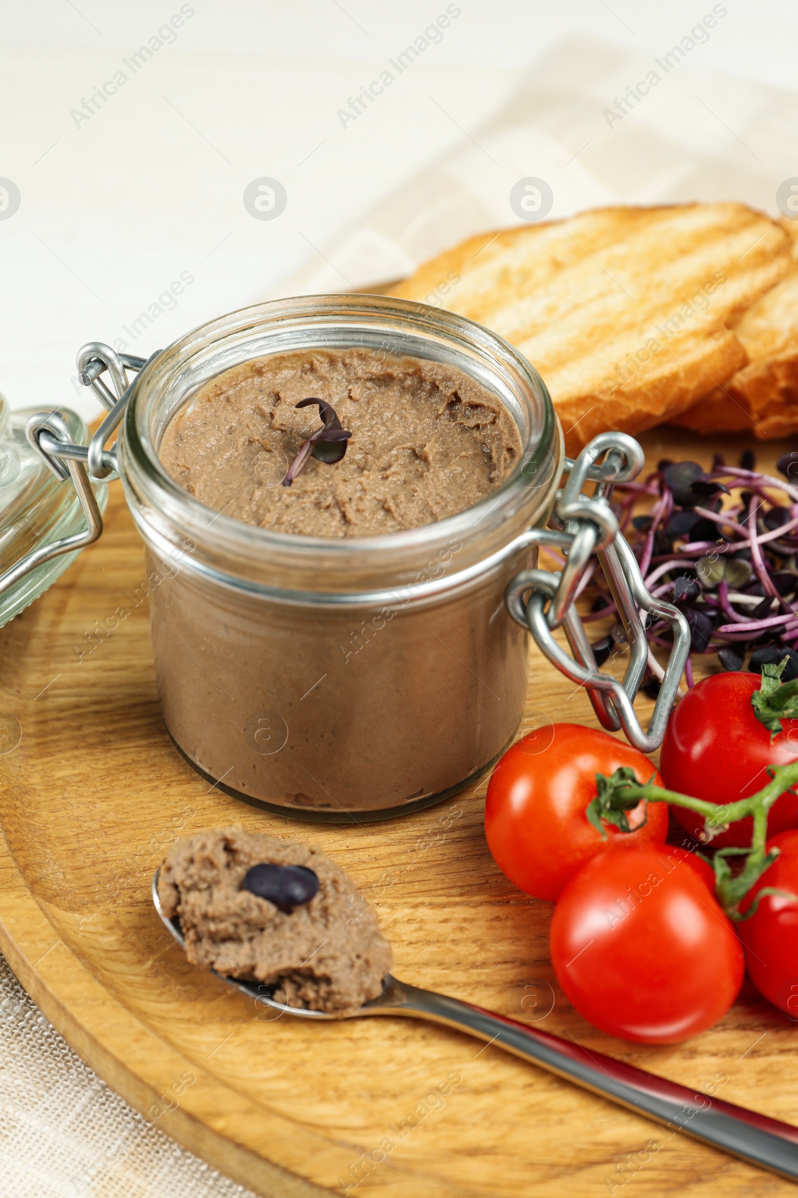 Photo of Delicious liver pate on wooden board, closeup view