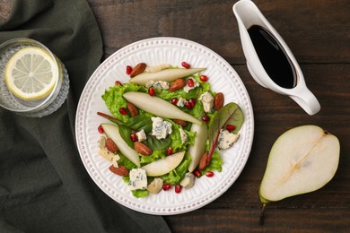 Photo of Delicious pear salad with sauce on wooden table, flat lay