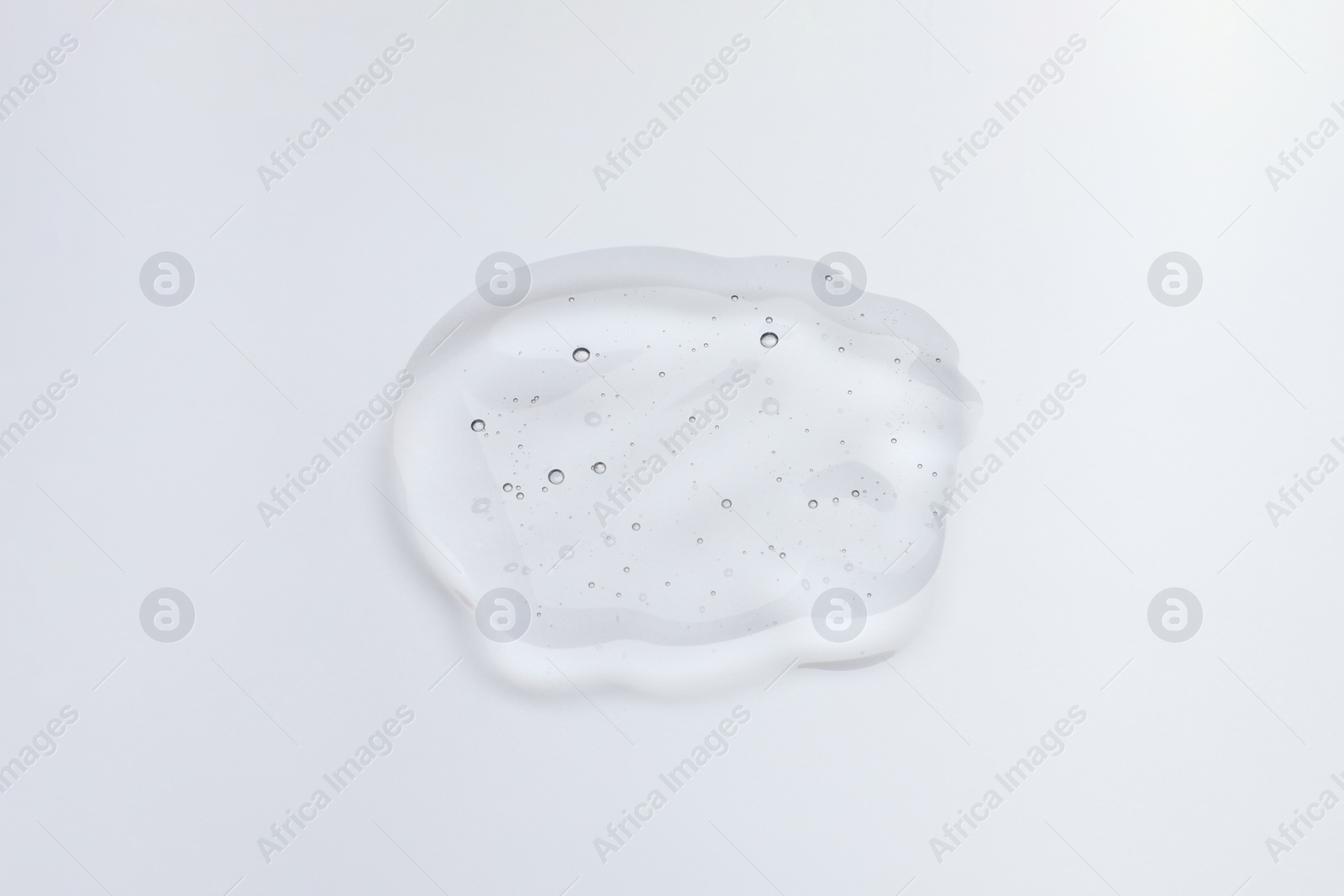 Photo of Sample of cosmetic oil on light background, above view