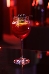 Photo of Glass of delicious refreshing sangria on table against blurred background