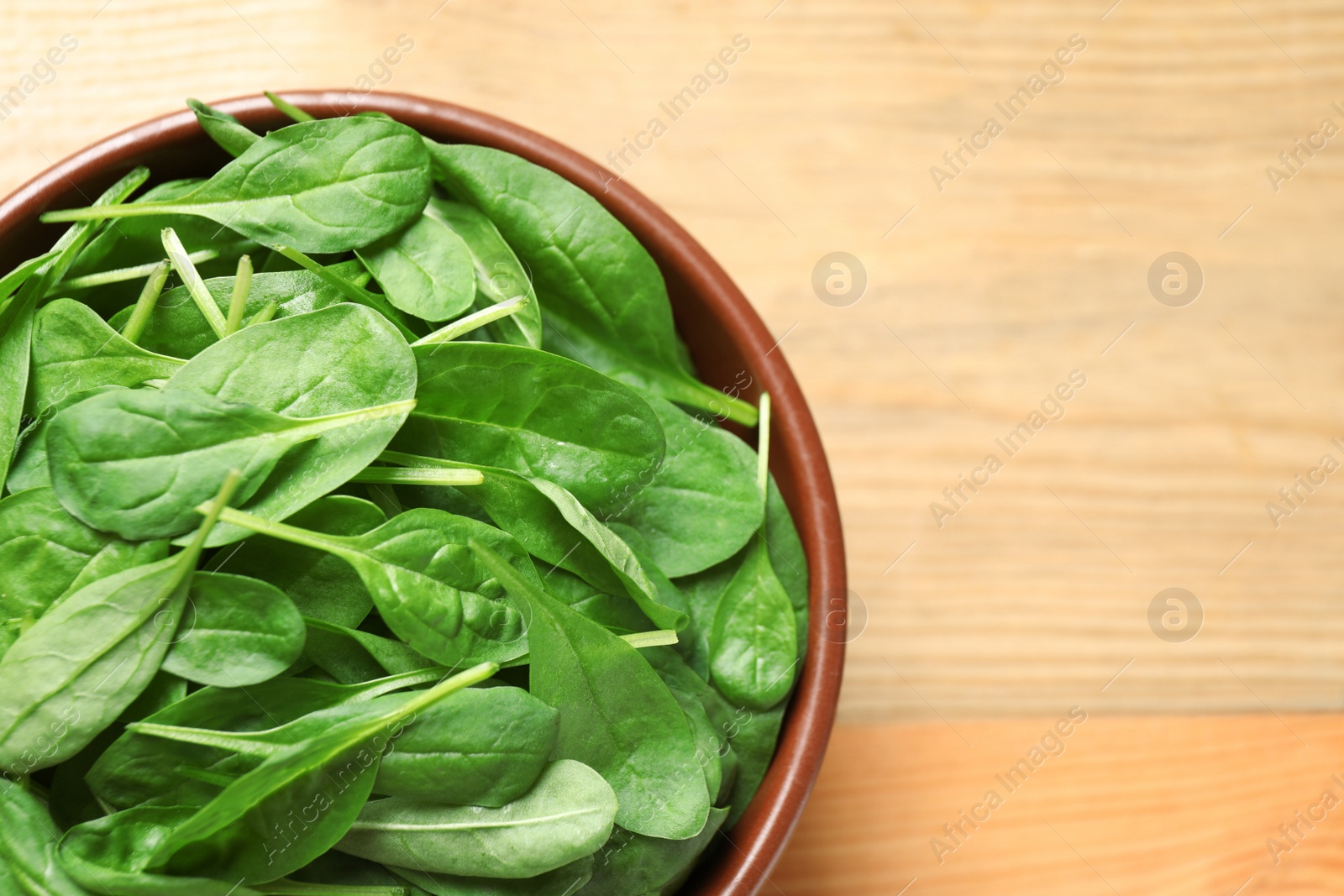 Photo of Fresh green healthy spinach on wooden table, top view. Space for text