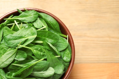 Fresh green healthy spinach on wooden table, top view. Space for text