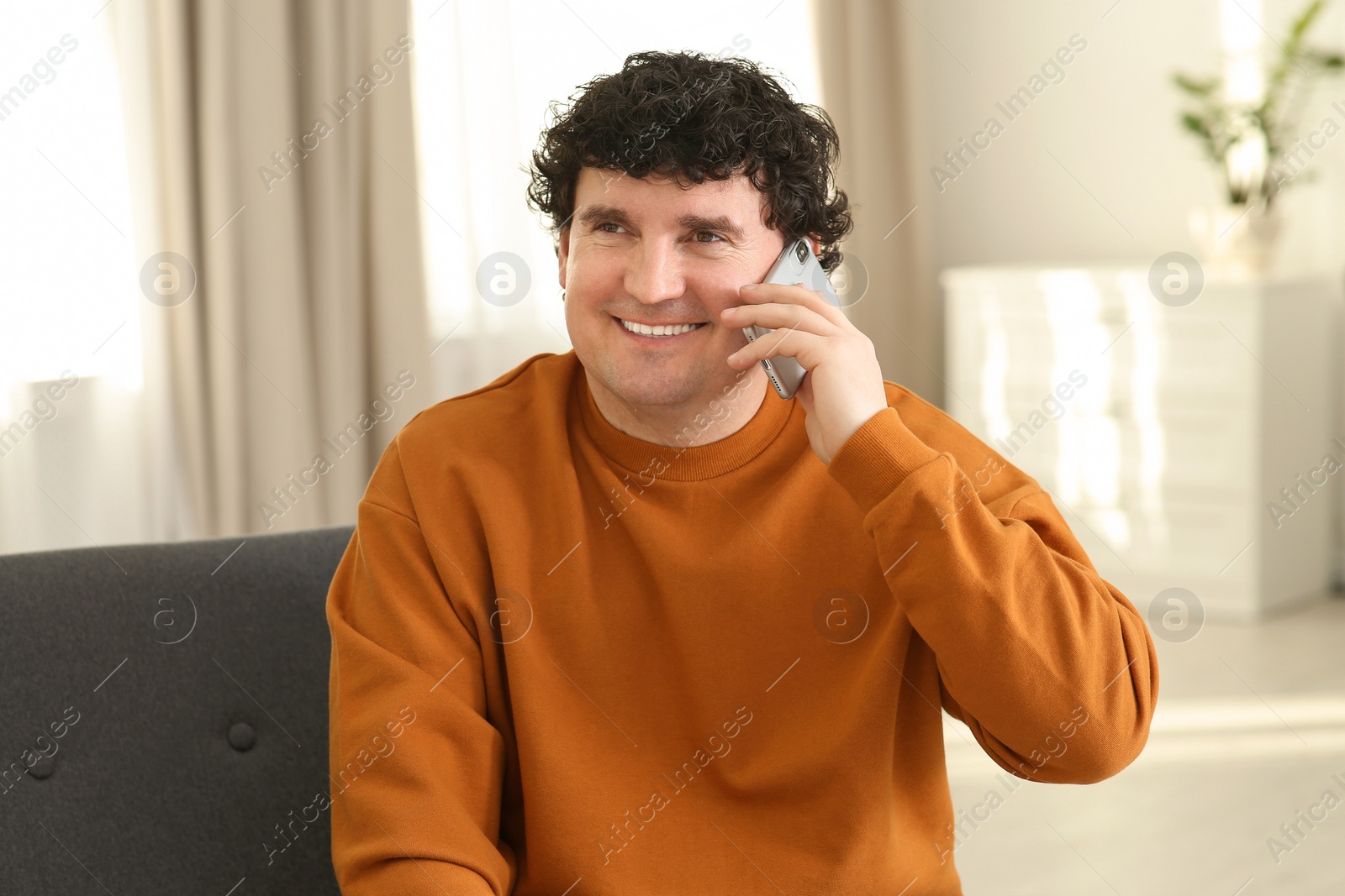 Photo of Mature man talking on mobile phone indoors