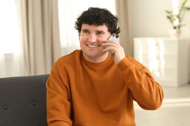 Mature man talking on mobile phone indoors