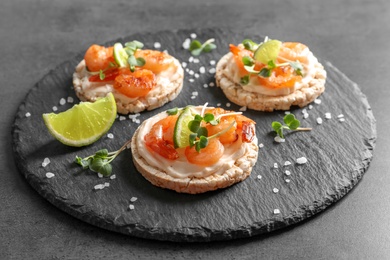 Photo of Delicious small sandwiches with shrimps on slate plate