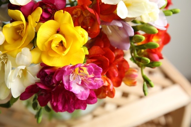 Photo of Beautiful spring freesia flowers on stand, closeup