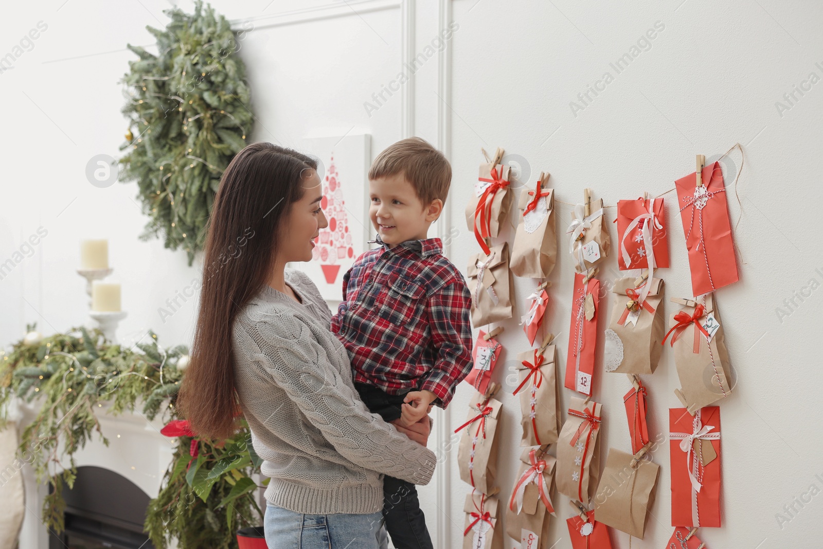 Photo of Mother and son near Advent calendar at home. Christmas tradition