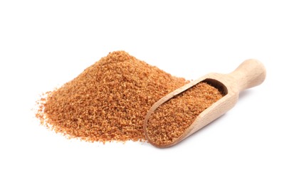 Photo of Natural coconut sugar and wooden scoop on white background