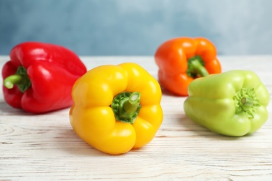 Photo of Ripe bell peppers on white wooden table