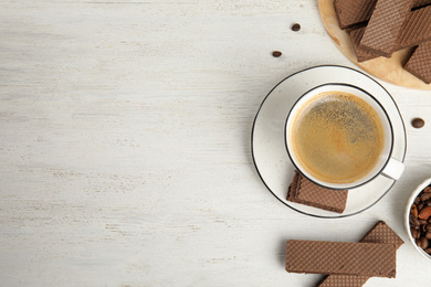 Photo of Breakfast with delicious wafers and coffee on white wooden table, flat lay. Space for text