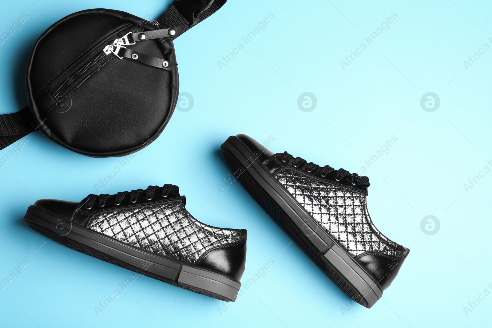 Photo of Flat lay composition of stylish shoes and bum bag on color background