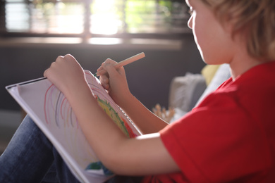 Photo of Little boy drawing at home, closeup. Creative hobby