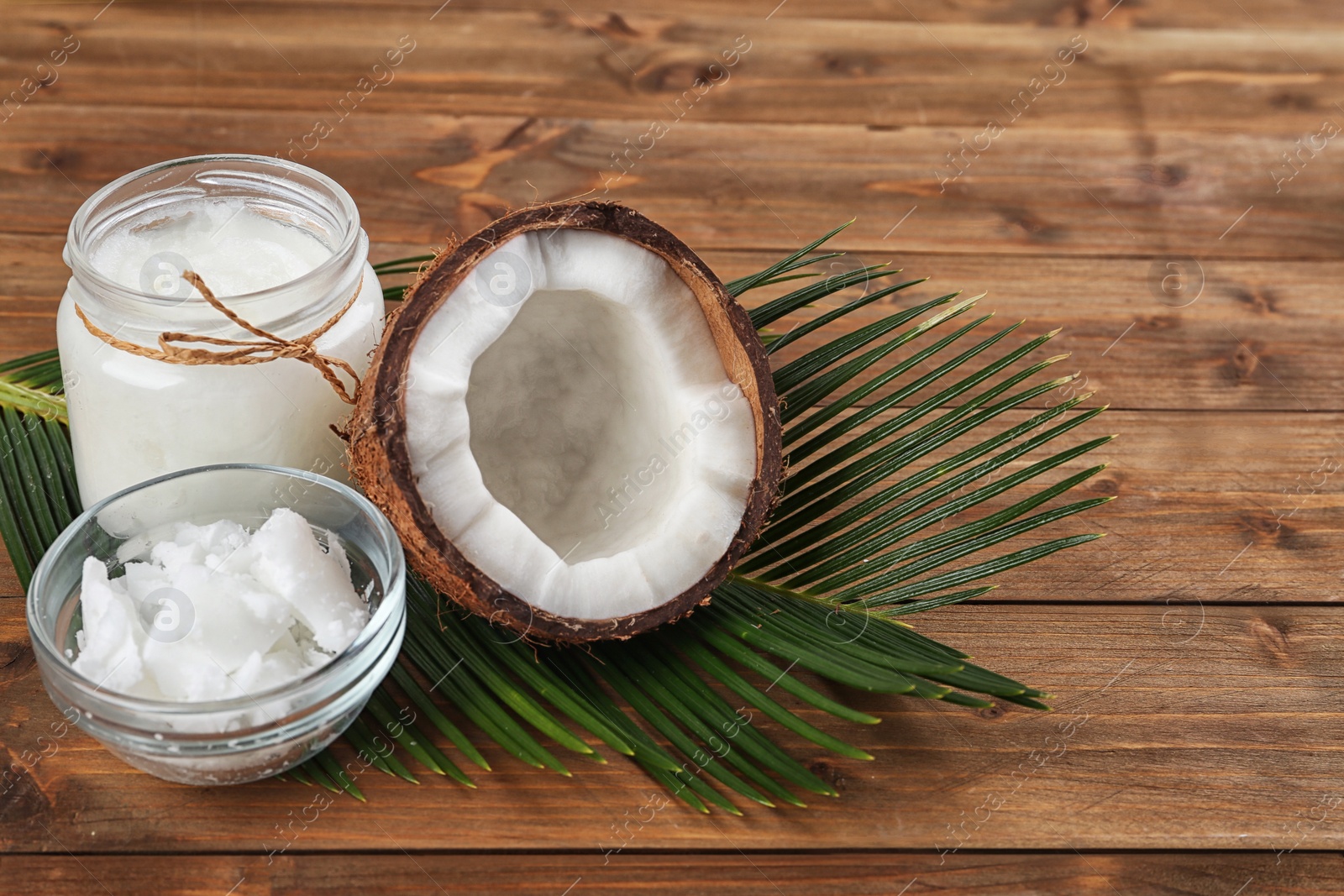 Photo of Composition with organic coconut oil on wooden table. Healthy cooking