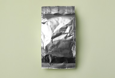 Photo of Blank foil package on light background, top view