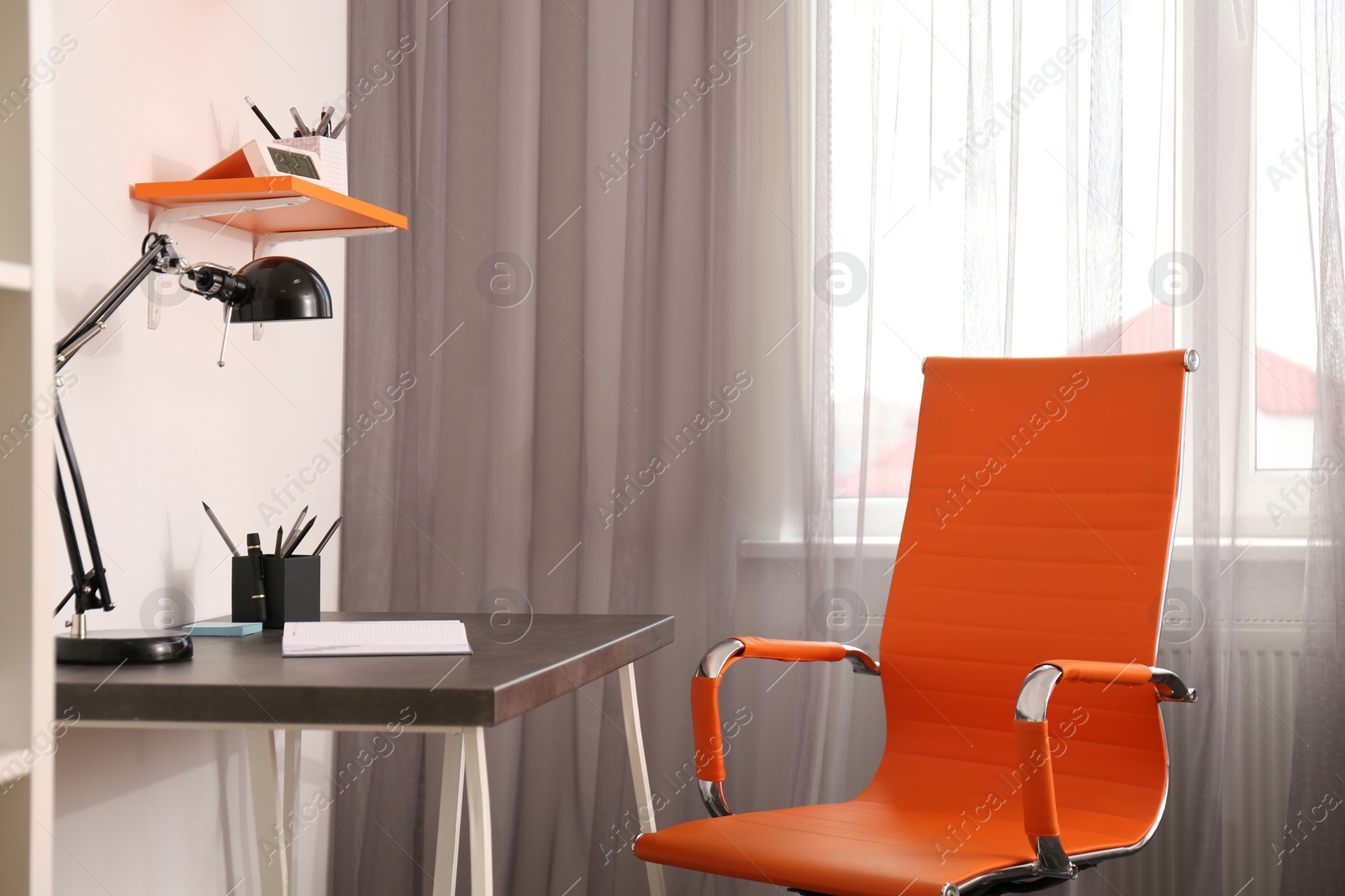 Photo of Stylish room interior with comfortable workplace near window. Design idea