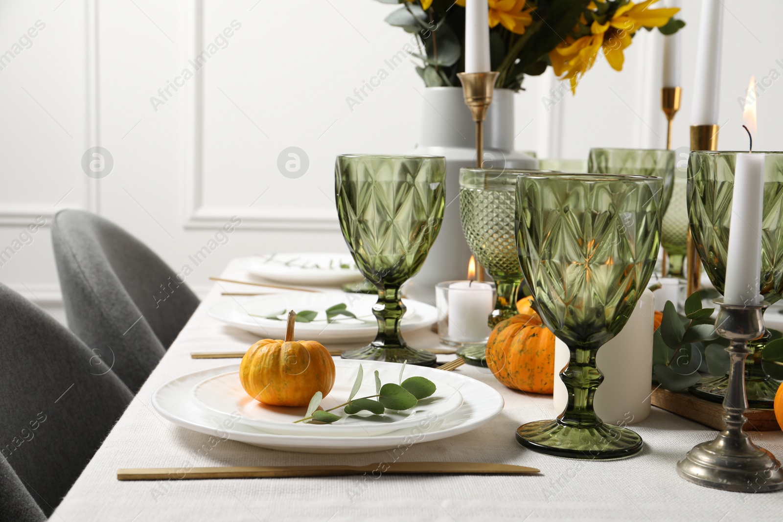 Photo of Beautiful autumn table setting. Plates, cutlery, glasses, pumpkins and floral decor