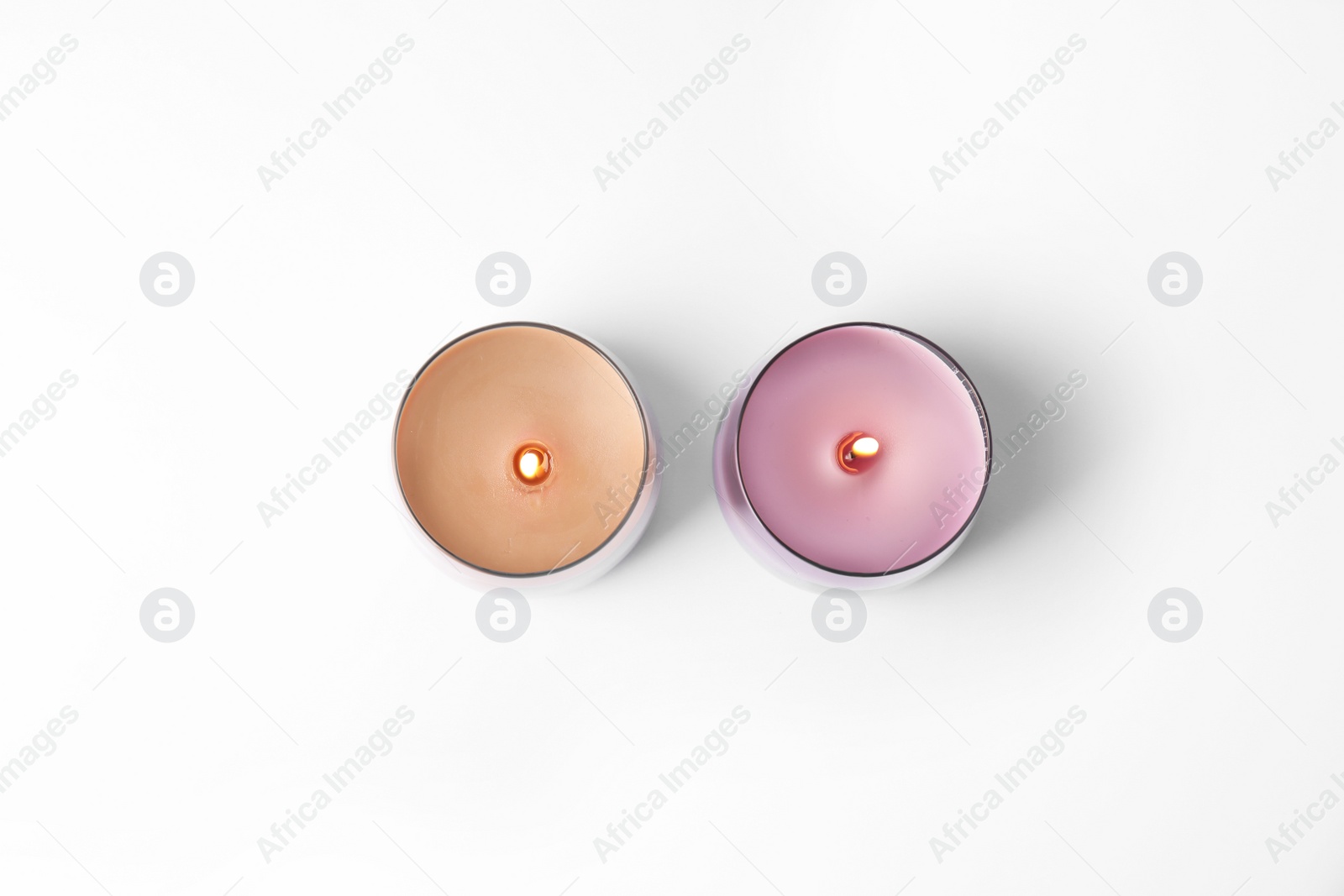 Photo of Color wax candles in glass holders isolated on white, top view