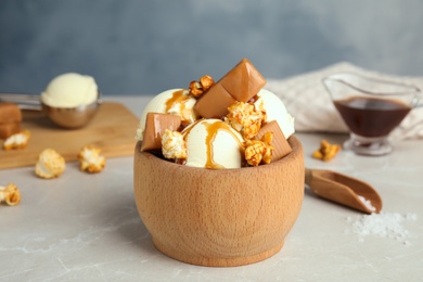 Photo of Delicious ice cream with caramel and popcorn served on table