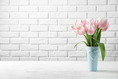 Photo of Vase with beautiful tulips for Mother's Day on table