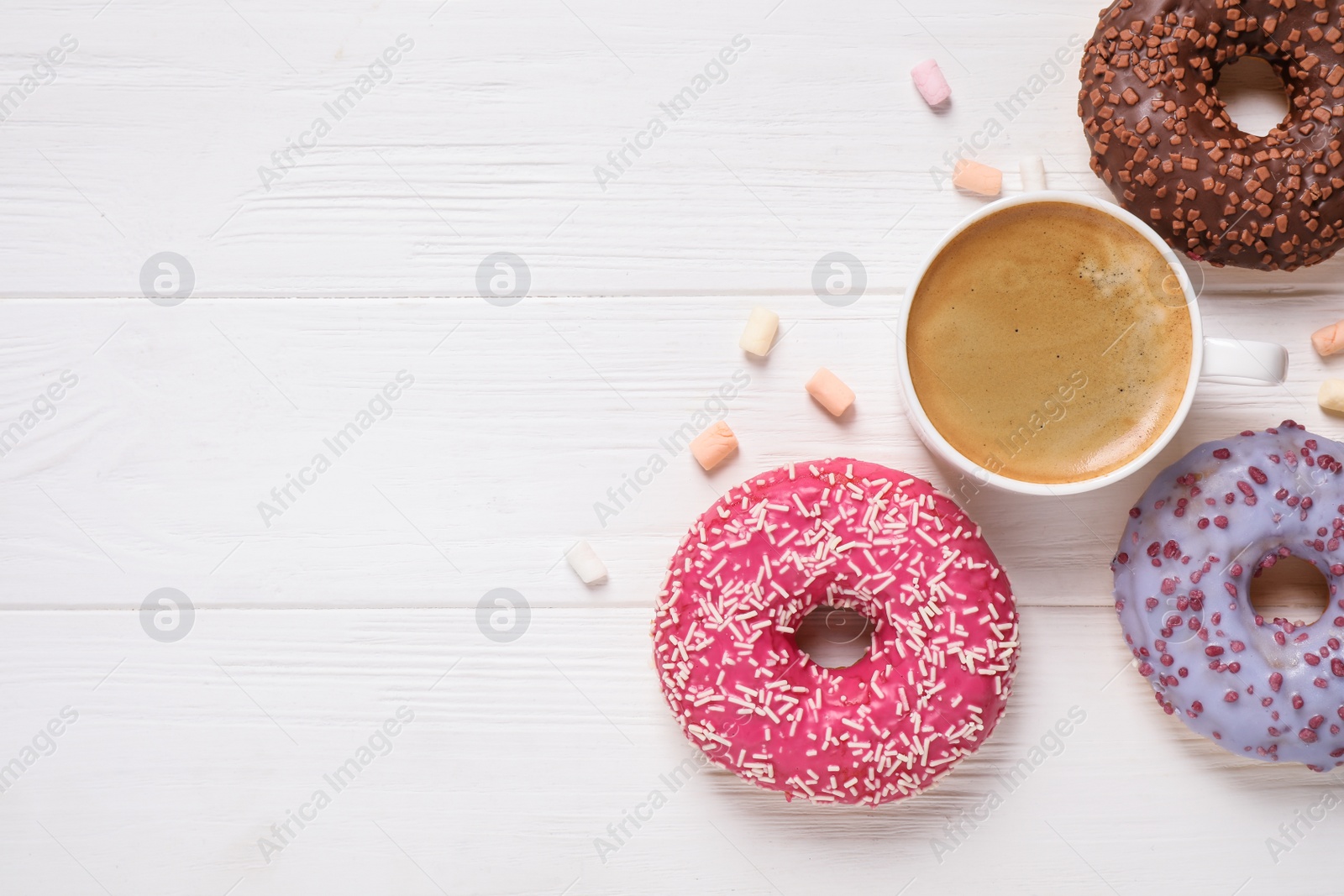 Photo of Flat lay composition with yummy donuts on white wooden background, space for text