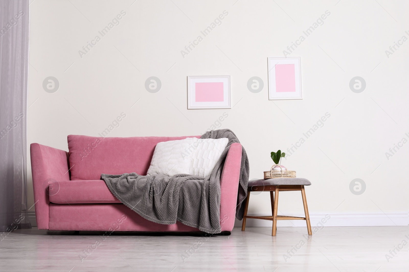 Photo of Cozy living room interior with sofa, pillow and plaid near light wall. Space for text