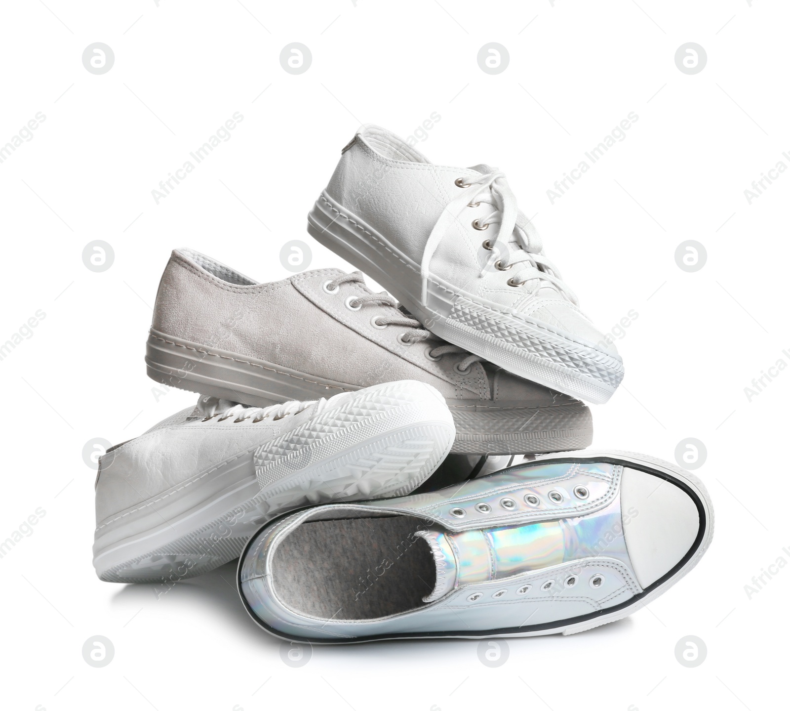 Photo of Heap of different sneakers on white background