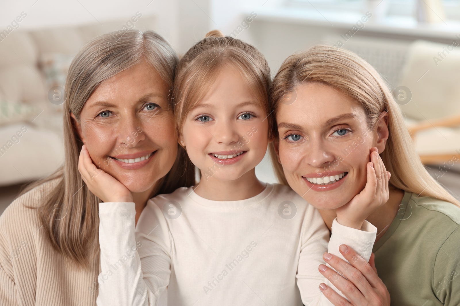 Photo of Three generations. Happy grandmother, her daughter and granddaughter at home