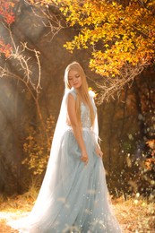 Beautiful girl wearing fairy dress in autumn forest