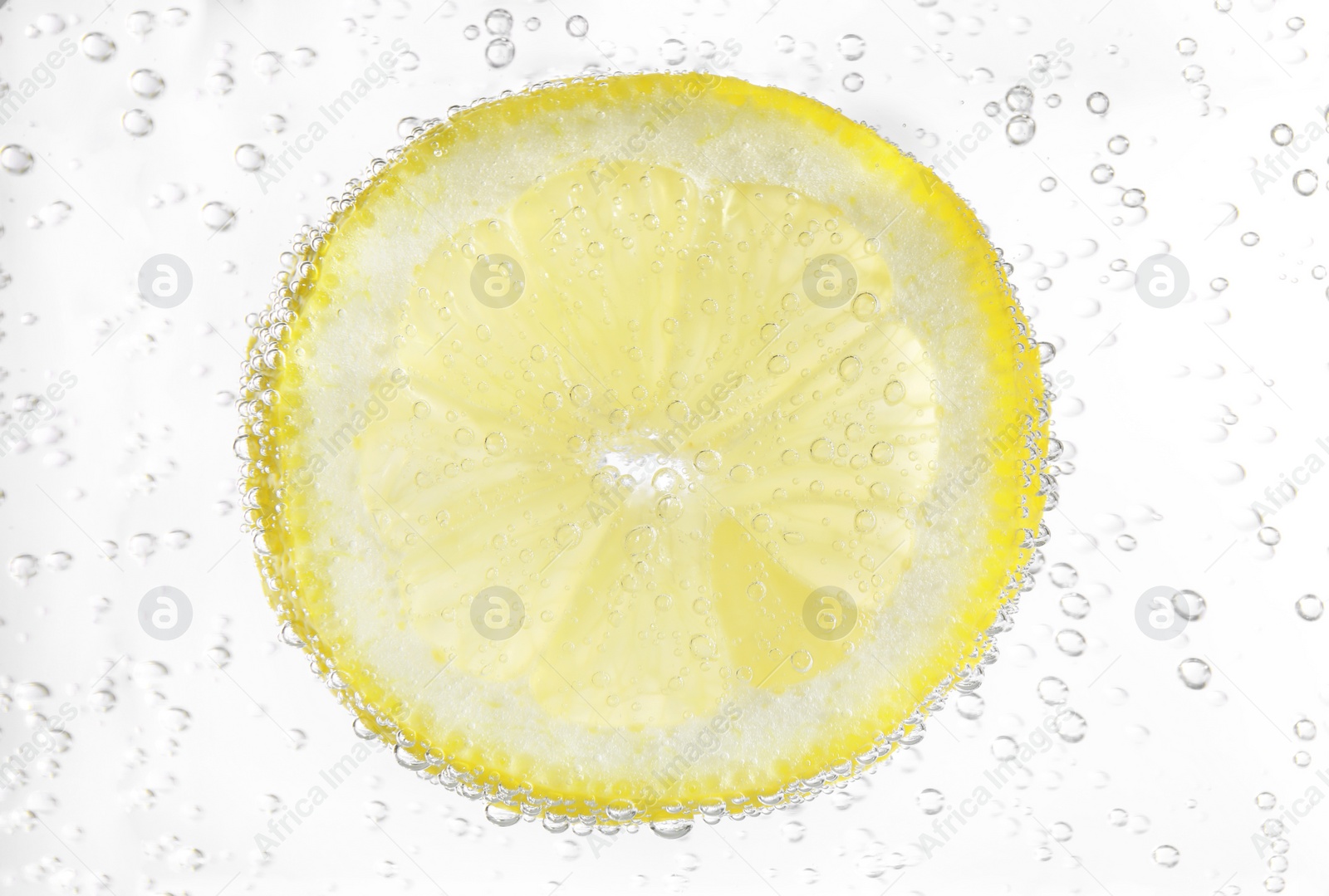 Photo of Juicy lemon slice in soda water, closeup