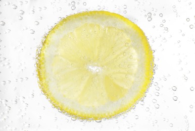 Juicy lemon slice in soda water, closeup