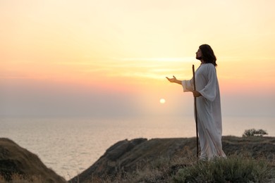 Photo of Jesus Christ on hills at sunset. Space for text
