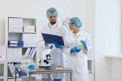 Photo of Quality control. Food inspectors checking safety of products in laboratory