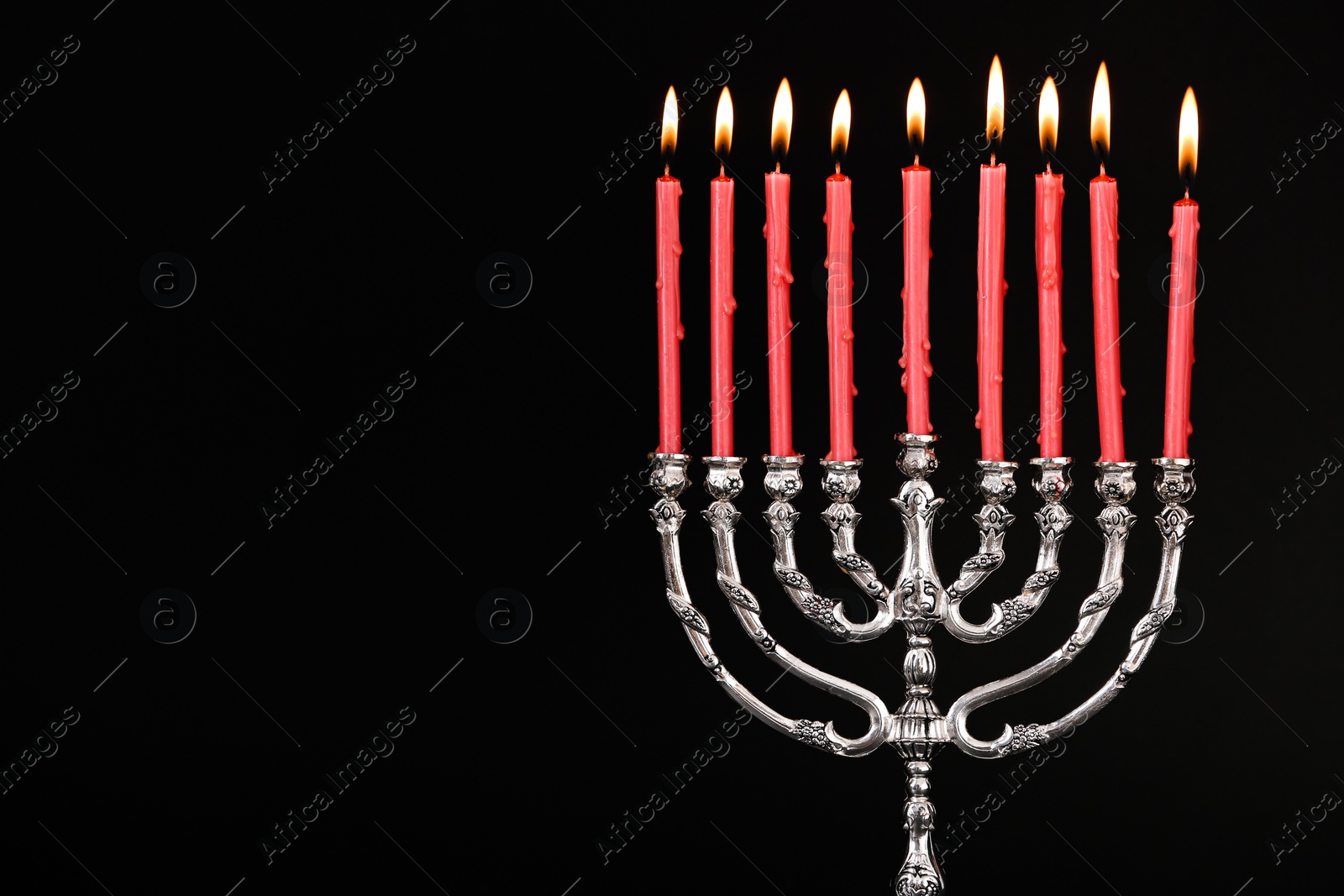 Photo of Silver menorah with burning candles on black background, space for text. Hanukkah celebration