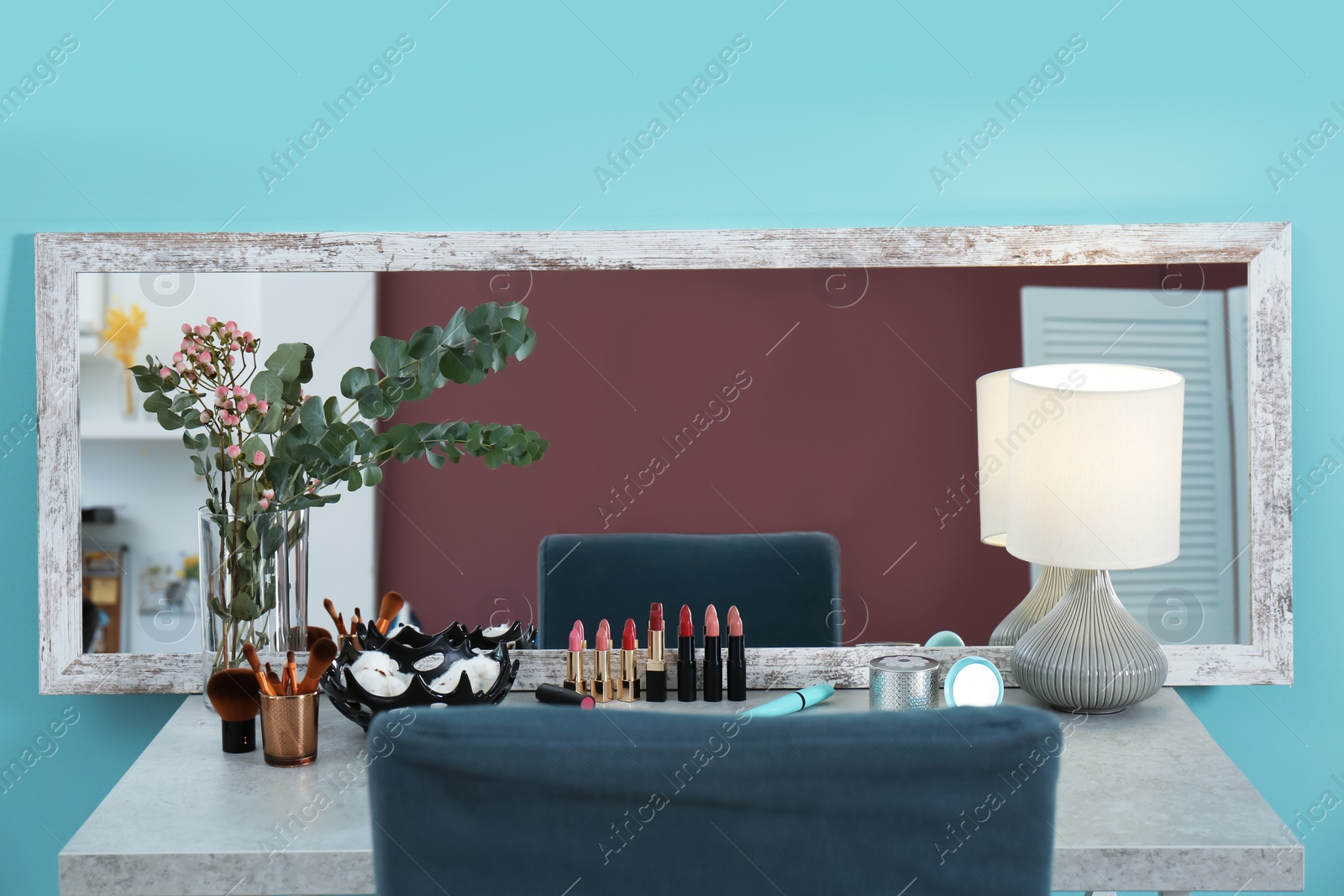 Photo of Decorative cosmetics and tools on dressing table near mirror in makeup room