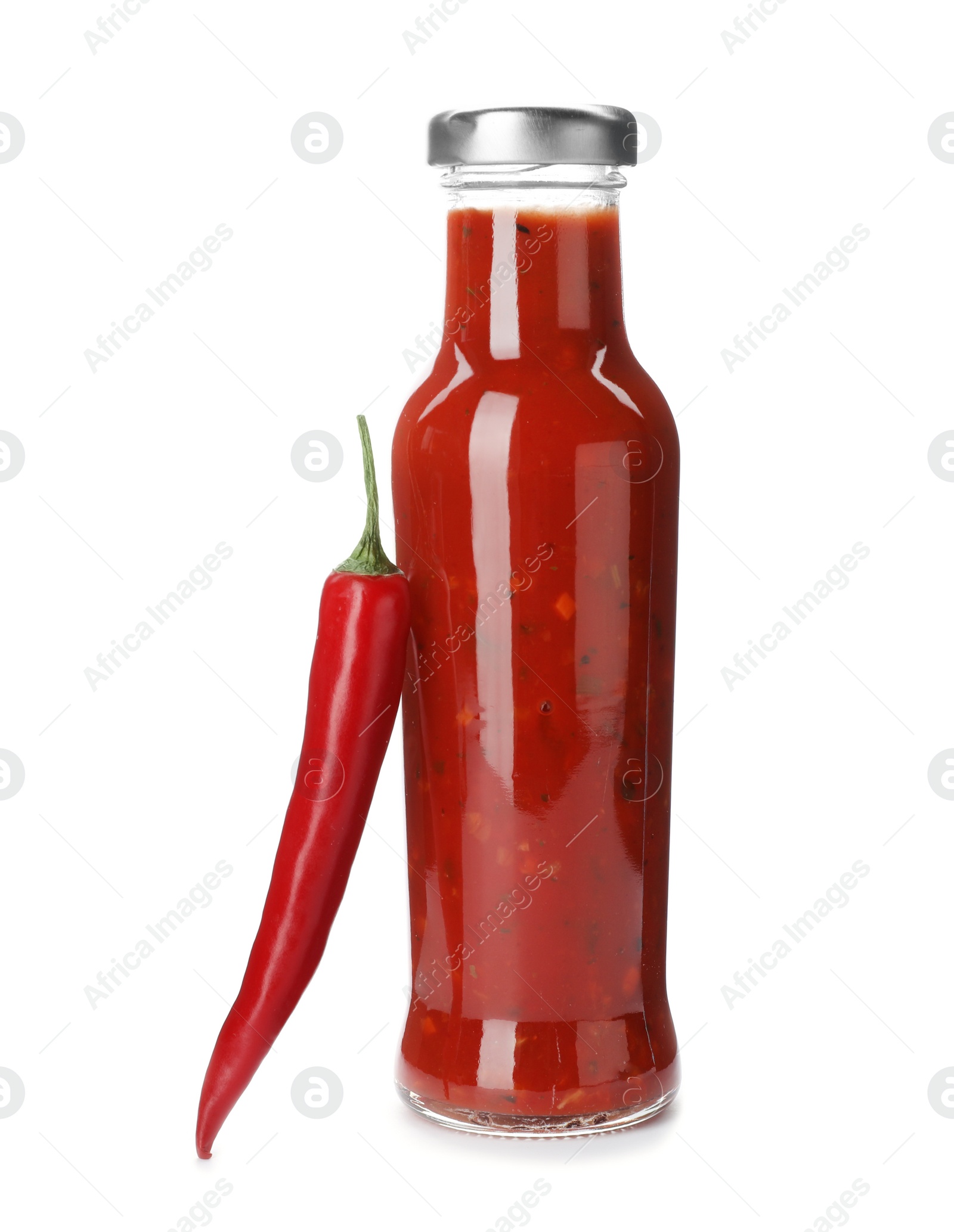 Photo of Bottle with spicy chili sauce and fresh pepper on white background