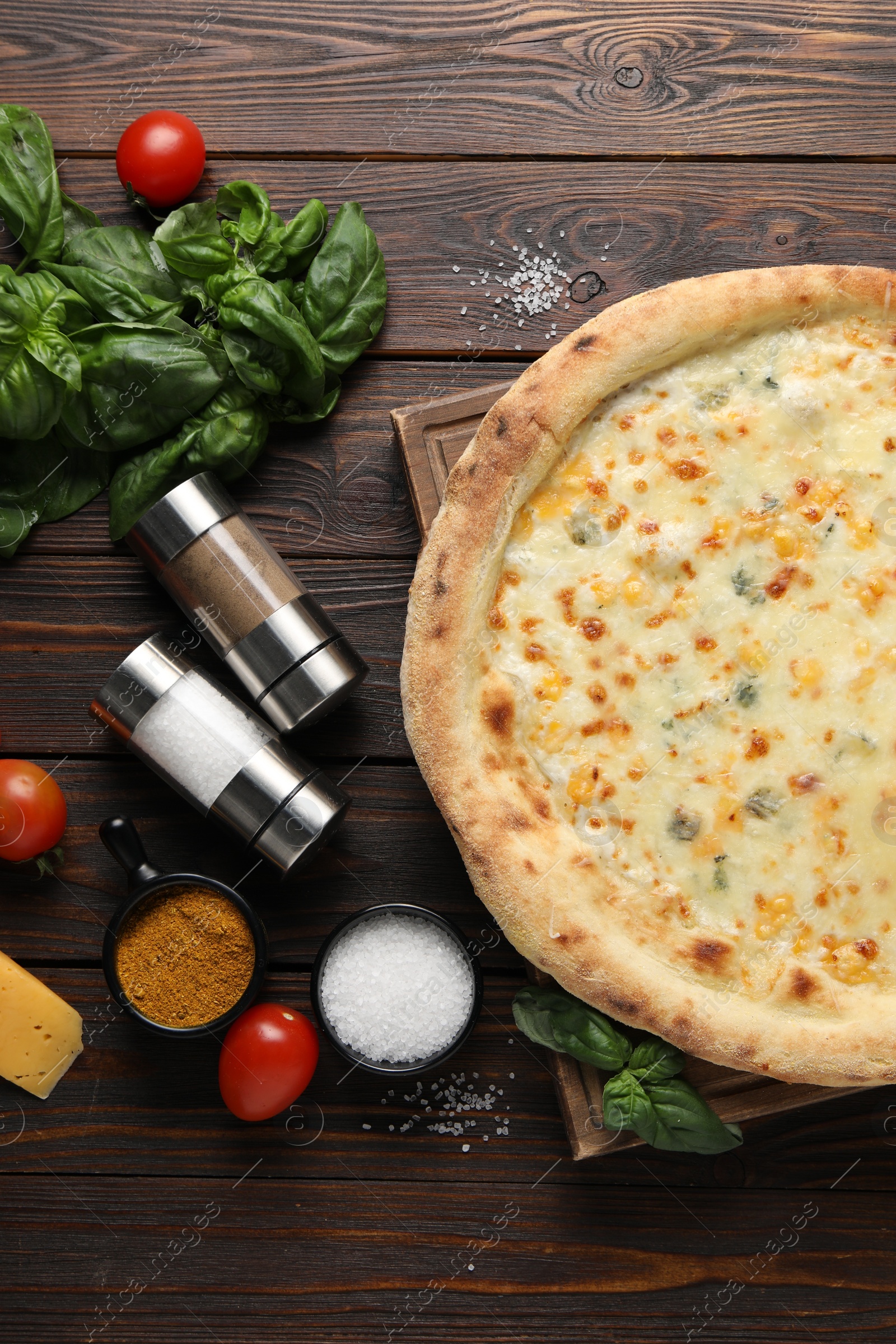 Photo of Flat lay composition with delicious cheese pizza and ingredients on wooden table