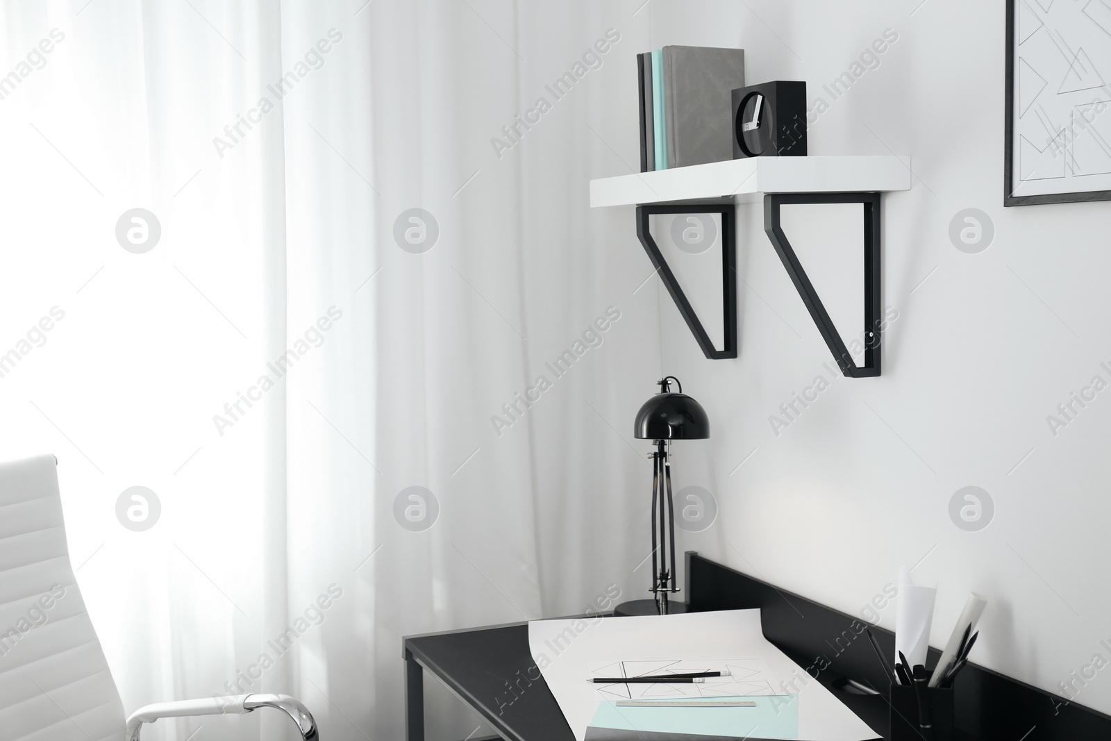 Photo of Stylish room interior with comfortable workplace near window. Design idea