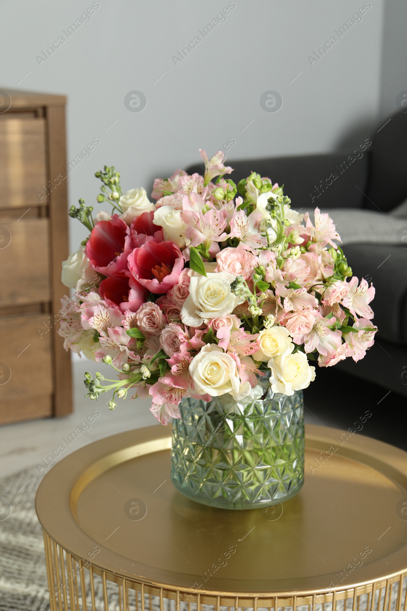 Photo of Beautiful bouquet of fresh flowers on coffee table in room