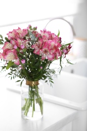 Photo of Vase with beautiful alstroemeria flowers on countertop in kitchen. Interior design