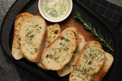 Tasty baguette with garlic and dill served on grey table, top view