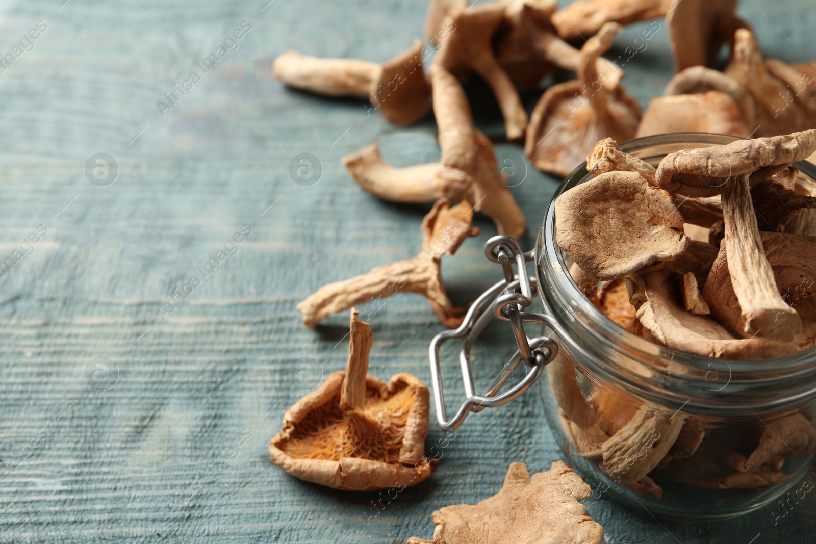 Photo of Composition of dried mushrooms and glass jar on table, closeup. Space for text