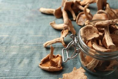 Photo of Composition of dried mushrooms and glass jar on table, closeup. Space for text